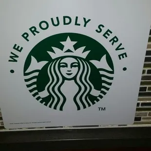 a starbucks sign on a brick wall
