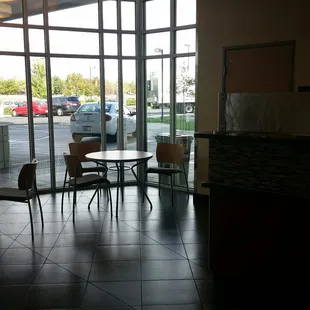 tables and chairs in front of a large window