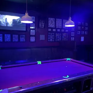 a pool table with neon lights