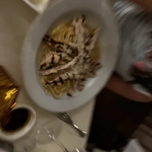 a plate of pasta and a bottle of wine