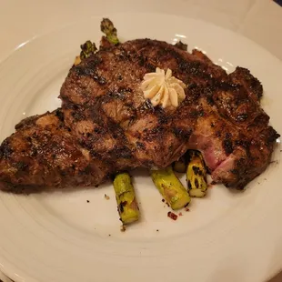 Ribeye with asparagus on top of roasted potatoes.