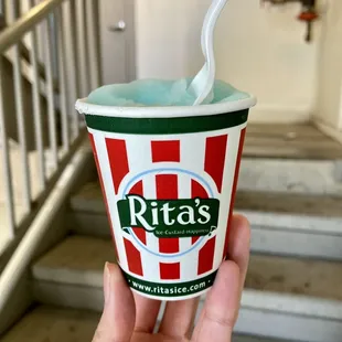 a hand holding a cup of ice cream