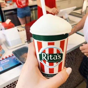 a hand holding a cup of ice cream