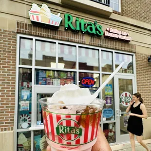 a hand holding a cup of ice cream