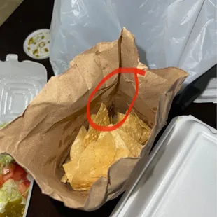 a tortilla and chips in a paper bag