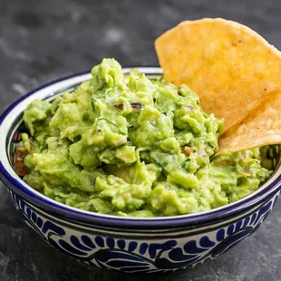 a bowl of guacamole with chips