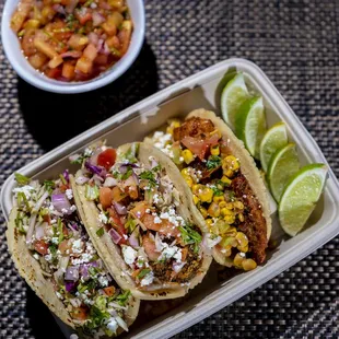 three tacos and a bowl of salsa