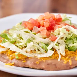 a taco topped with lettuce and tomatoes