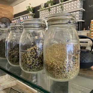 a row of glass jars filled with various types of coffee