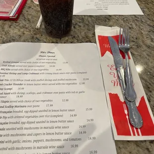 a menu and a drink on a table