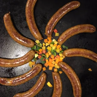 a bunch of sausages on a black plate