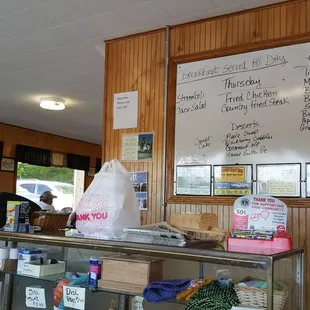 a view of a counter with a menu on the wall