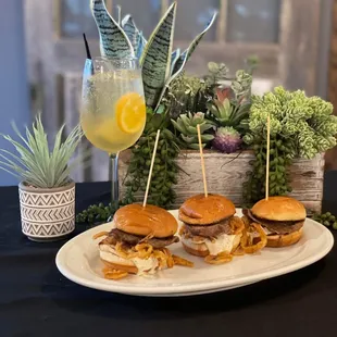 a plate of sliders and a drink