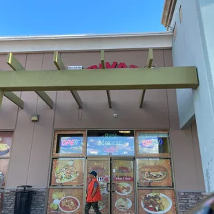  a man walking in front of a restaurant