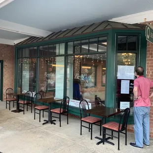 a man standing in front of a restaurant