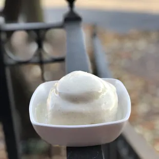 a bowl of ice cream on a railing