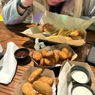 We got a salmon/avocado sushi roll, jalapeño poppers, fried pickles and chicken strips w fries.