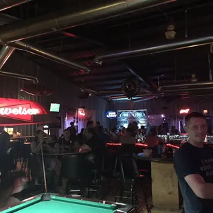 a man standing in front of a pool table