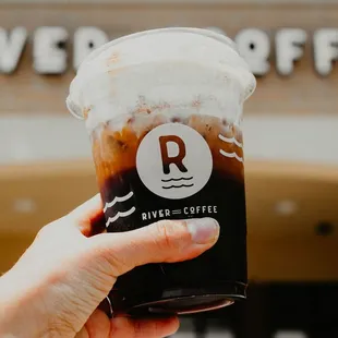 a hand holding a cup of coffee