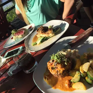 a woman sitting at a table with plates of food