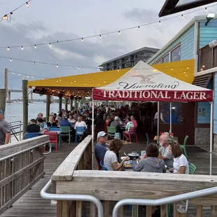 people sitting at tables under umbrellas
