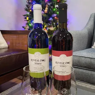 two bottles of wine and a glass of wine