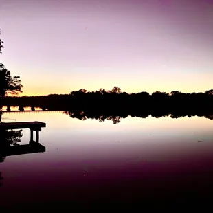 a dock at sunset on a lake