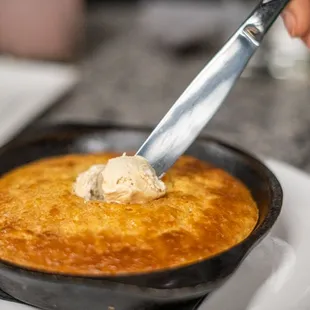 a person holding a knife in a bowl of food