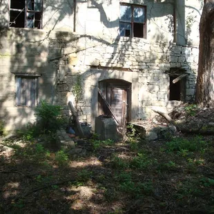 This photo shows the south side of the mill.  You can see concrete pedestals in front of the lower door...