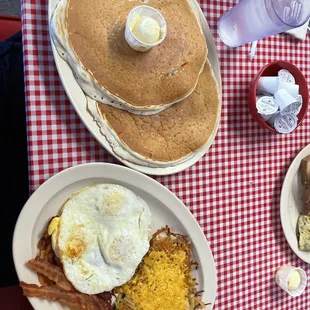 a breakfast of pancakes, eggs, bacon and hash browns