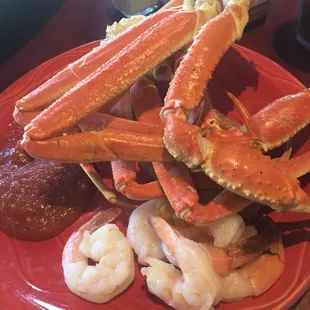 a plate of crab legs, shrimp, and other seafood items