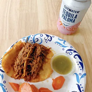 2 cochinita tacos, mildly spicy carrots, and green sauce. The canned cocktail is from the liquor store next door.