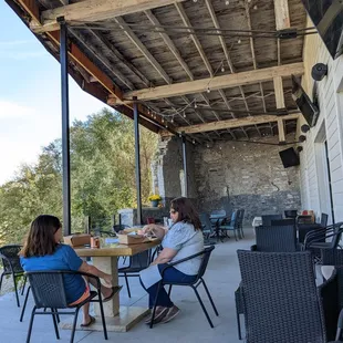 two women sitting at a table on a patio