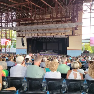 a large crowd of people sitting in front of a stage