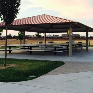 One of three large covered areas with long picnic tables and two dedicated charcoal grills each