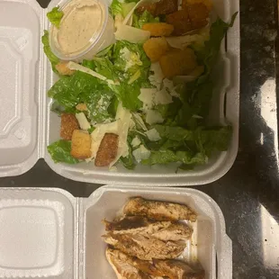 a salad and chicken in a styrofoam container