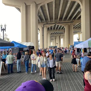 a large group of people standing under a bridge