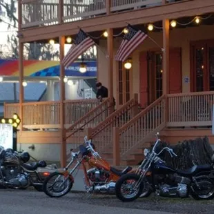 a row of motorcycles parked in front of a bar