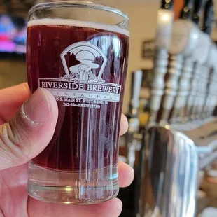 a hand holding a glass of beer