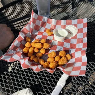 a basket of chicken nuggies and a glass of water