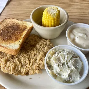 Country bumpkin (chicken fried steak), buttered corn on the cob, and baked potato salad