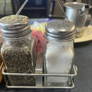 Black things floating around in salt shaker and what seems to be dried gravy caked on the top of the pepper shaker.