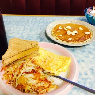 Cheese omelet with hash browns and wheat toast. With a pancake! Yum!
