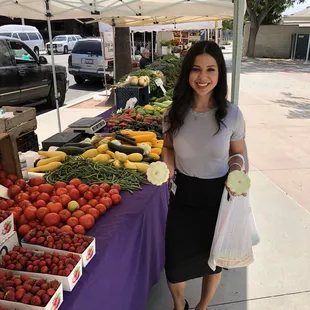  woman standing in front of a display of produce