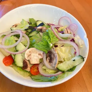 House salad. Chipped bowl with wilted leaves and discolored mushrooms.