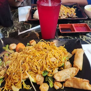 My yakisoba with broccoli, bean sprouts, carrots, onions, celery, seafood, and tofu with spring rolls and gyoza and a glass of lemonade.