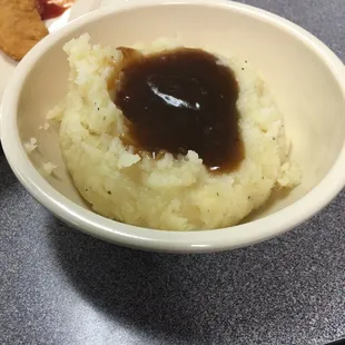 a bowl of mashed potatoes and a plate of fried chicken
