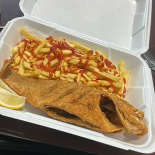 a fish and fries in a styrofoam container