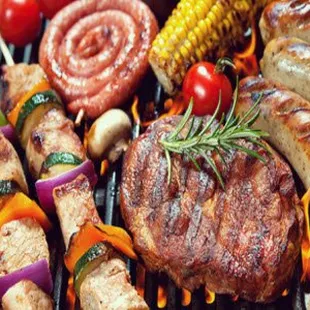 a variety of meats and vegetables on a grill