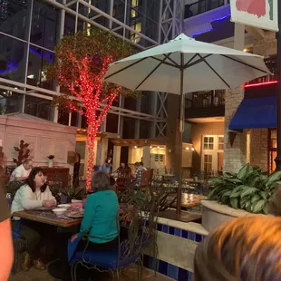 people sitting at tables under umbrellas